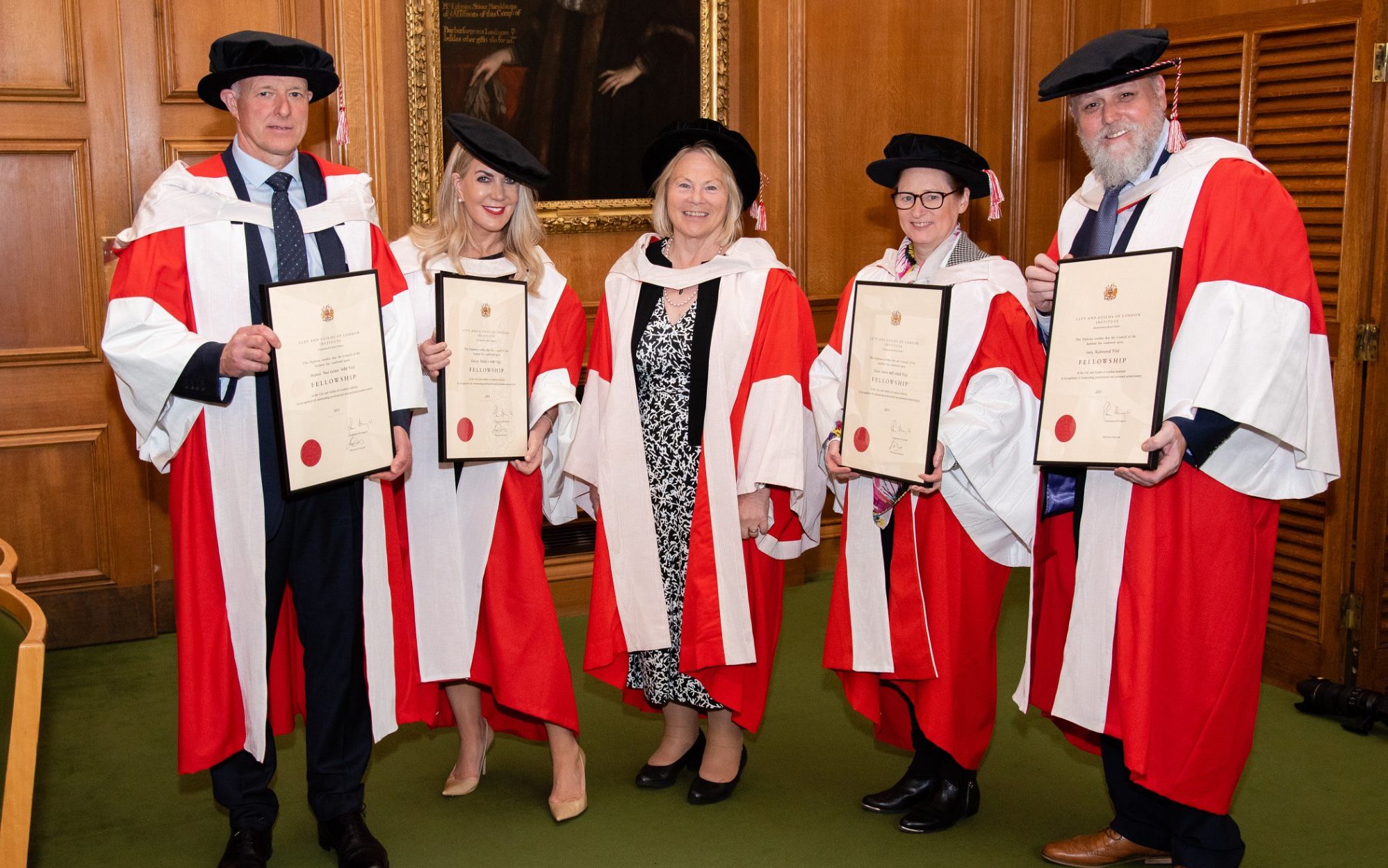 2022 Fellows posing with certificates wearing Fellows robes